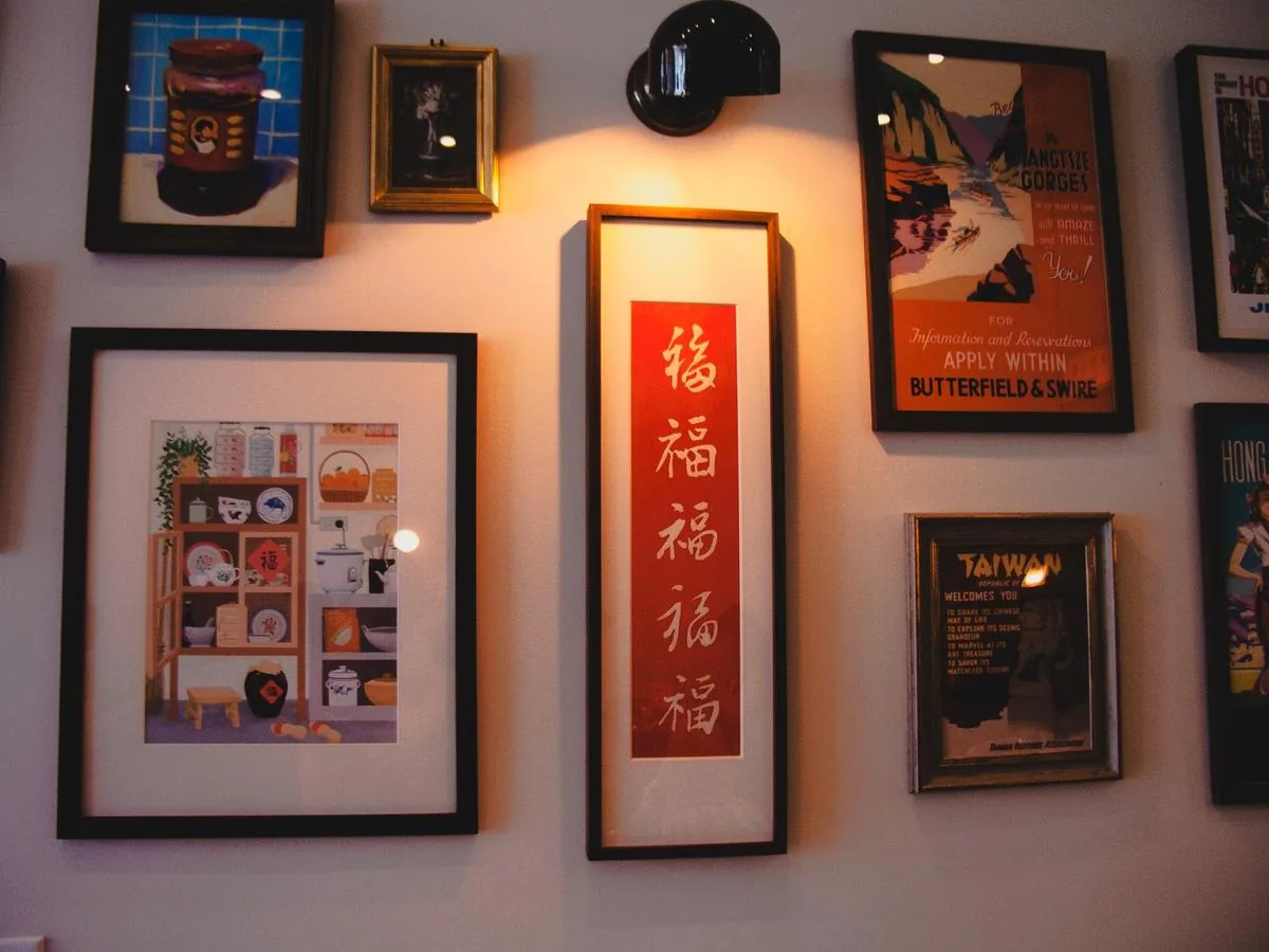 Gallery wall — vintage posters and brass sconce
